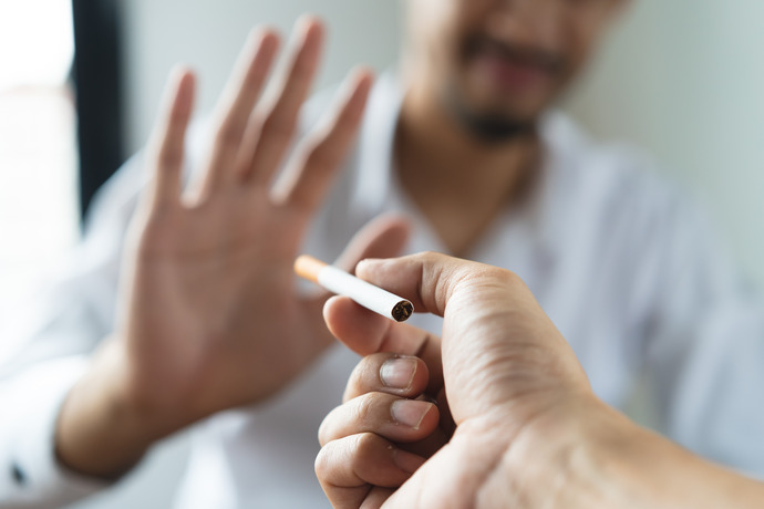 Hombre rechazando un cigarrillo porque está dejando de fumar