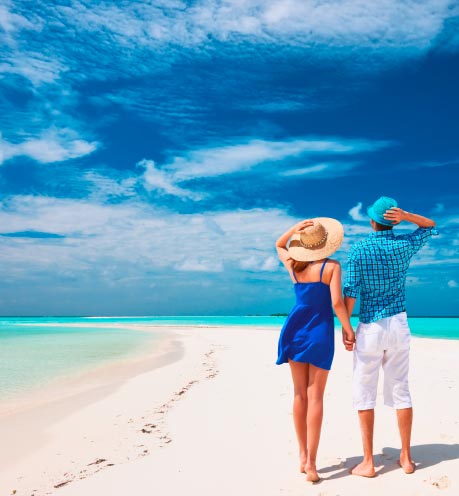 Una pareja de la mano caminando en la playa