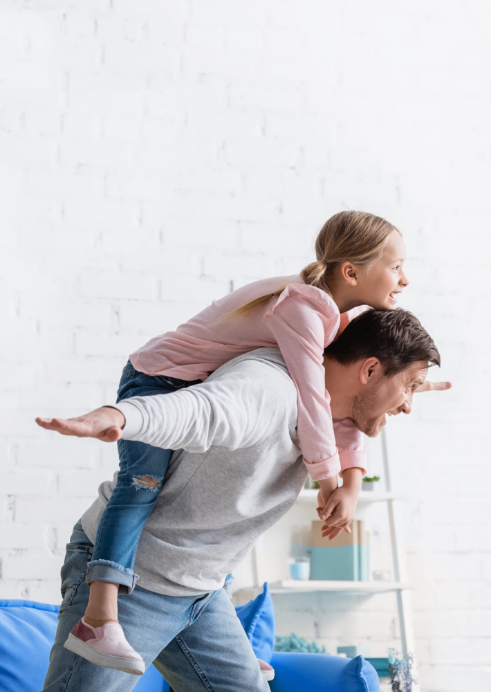 Hombre jugando con su hija al avión.