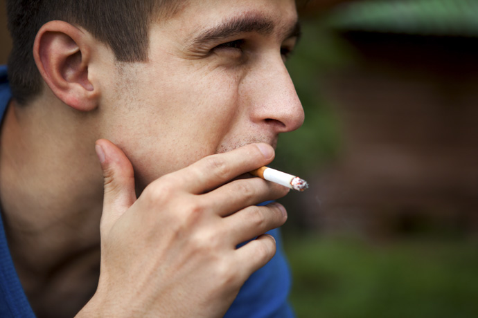 Hombre joven fumando cigarrillo 