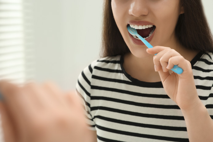 Mujer usando cepillo de dientes