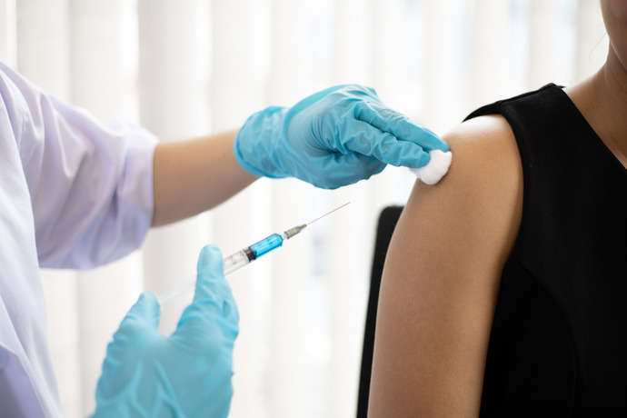 Personal sanitario a punto de poner una vacuna en el brazo de una mujer