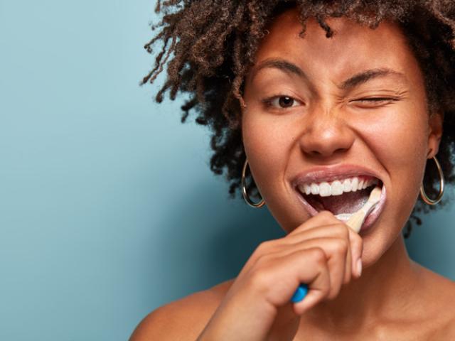 Mujer mostrando técnicas de cepillado dental.
